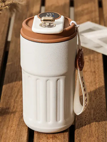 Smart digital thermal bottle with LED temperature display and brown lid on wooden surface.